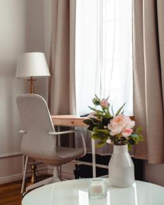 萨勒河畔哈雷Grâce Boutique Apartments的花瓶坐在窗边的桌子上