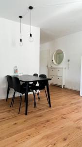 曼海姆2 ZKB Apartment in Mannheim的一间用餐室,配有黑色的桌子和椅子