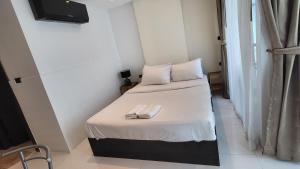 北芭堤雅帕塔萨蒙斯瑞恩特沃盖玛特公寓的小房间设有两张床,上面有餐巾
