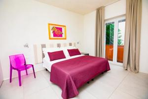 里乔内Prime blue suite - Giardini的卧室配有粉红色的床和粉红色的椅子