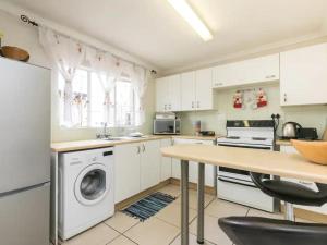 约翰内斯堡Parkhurst Cottage的厨房配有洗衣机和桌子