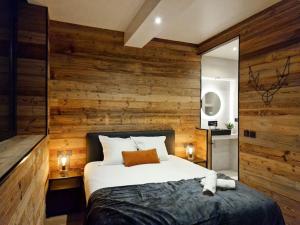 安锡Le Enecy - Spa - Cœur Vieille ville的一间卧室设有木墙和一张大床