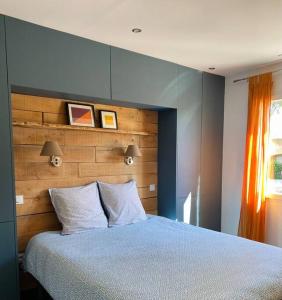 滨海阿热莱斯CASA LUIS - Bel appartement avec piscine et proche de la mer的一间卧室配有一张大床和木制床头板
