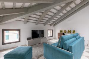 奇塔代拉Corte alle mura - Mansarda lux的客厅配有蓝色椅子和平面电视