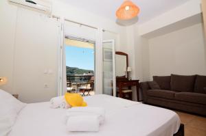帕尔加Villa Ektoras by EY Villas的一间卧室配有一张白色床,上面有黄色帽子