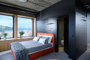 卢布尔雅那Delo 2.0.的一间设有橙色床的卧室,位于带窗户的房间内