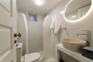 伊亚The Bay - Loft apartment Sea & Sunset View的白色的浴室设有水槽和镜子
