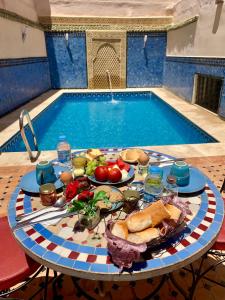 梅克内斯里亚德扎拉阿尔伊斯梅利亚住宿加早餐旅馆的游泳池旁带餐盘的桌子