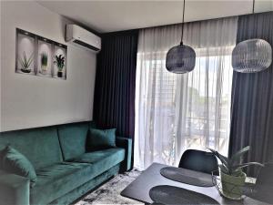 维尔纽斯Aurea apartment的客厅配有绿色沙发和桌子
