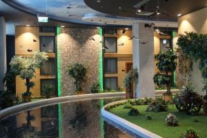 巴库Midtown Hotel Baku的酒店大堂设有游泳池和植物