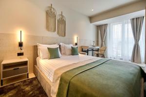 北马马亚-讷沃达里Alezzi Infinity Aparthotel & Spa的酒店客房设有一张大床和一张桌子。