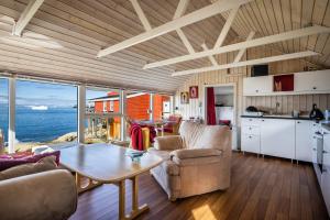 伊卢利萨特Jomsborg Ilulissat的厨房以及带桌椅的起居室。