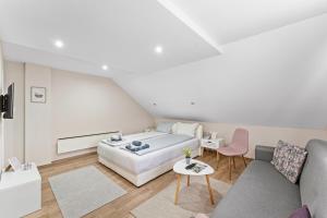 索科矿泉村M Apartments的白色卧室配有床和沙发