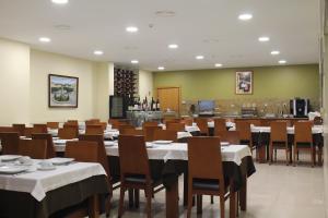 蒙考Hotel Dom Afonso - Monção的一间带桌椅的用餐室和一间厨房