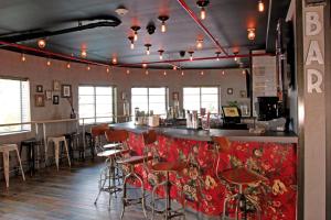 迈阿密海滩Hotel Gaythering - Gay Hotel - All Adults Welcome的餐厅内带红色椅子和柜台的酒吧