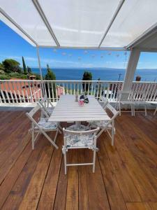 皮兰Sunrise SeaView Apartment Fiesa的海景甲板上的白色桌椅
