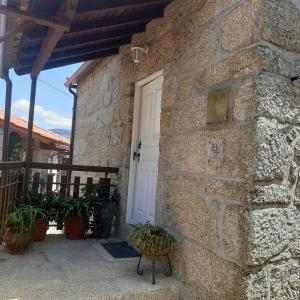 索茹Casa de Bairros的一座石屋,有白色的门和植物