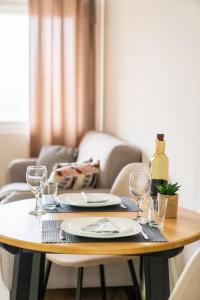 索科矿泉村M Apartments的一张木桌,上面放有盘子和酒杯