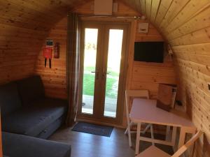 海布里奇Wall Eden Farm - Luxury Log Cabins and Glamping的一间配有沙发、桌子和门的房间