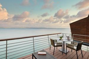 纳沙泰尔帕拉菲特酒店的一个带桌椅的海景阳台