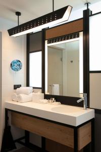 斯特拉斯堡Aloft Strasbourg Etoile的一间带水槽和大镜子的浴室