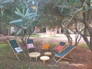 马拉喀什la Paysanne by Souna的坐在树下草上的一组椅子
