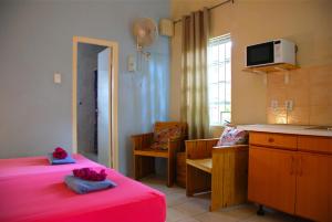 威廉斯塔德加勒比海弗拉沃公寓酒店的带两张床和一张桌子的房间以及一间厨房