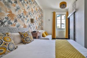 比亚里茨Hôtel Parc Mazon-Biarritz的卧室配有一张带黄色枕头的大型白色床。