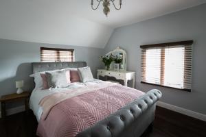 皇家滕布里奇韦尔斯Accommodation at Salomons Estate的一间卧室配有一张带粉色毯子和窗户的床。
