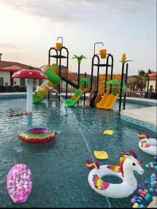 阿哈达منتجع الجزيرة الخضراء的一个带水上公园的游泳池,带游乐场