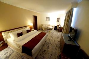 安曼Amman Paradise Hotel的一间带大床的卧室和一间客厅