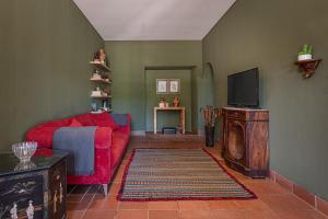 加维昂Alamal River Club的客厅配有红色沙发和电视