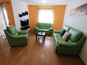 梅杜林Villa Antonia的客厅配有两张绿色沙发和一张桌子