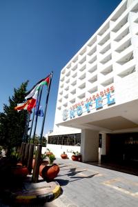 安曼Amman Paradise Hotel的大楼前有旗帜的酒店