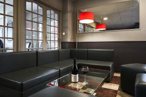 马尔桑奈拉科特Authentic by balladins Dijon / Marsannay-la-Côte的一间带沙发和一瓶葡萄酒的餐厅
