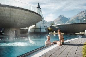 绍滕斯Ferienhaus Ötztal-Lodge的两名妇女在度假村的游泳池里