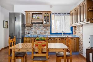 塞博河畔卡莱塔Apartamento Callao, La Graciosa的带木桌的厨房和带冰箱的厨房。