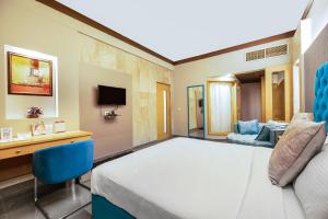 布巴内什瓦尔帕尔高地酒店的一间卧室配有一张床、一张桌子和一张沙发