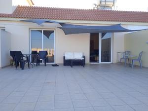 XylophaghouXylophagou Rest and relax (2) Ayia Napa Larnaca的一个带蓝伞、椅子和桌子的庭院