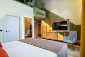 瓦伦西亚DWO Valencia的一间卧室设有一张床、一台电视和楼梯。