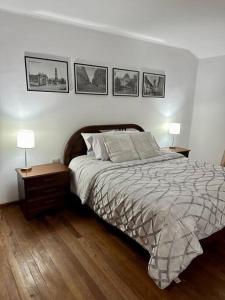 苏克雷Apartamento cómodo y céntrico的卧室配有一张床,墙上有三幅照片