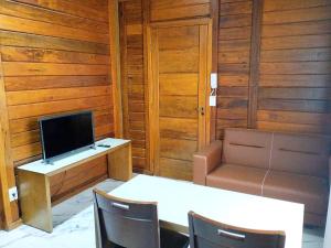 贝洛奥里藏特VIA SPE - Pousada的客房设有书桌、电视、桌子和椅子。