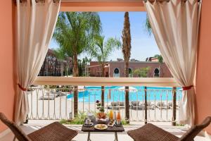 马拉喀什萨伏伊大酒店的从度假村的客厅可欣赏到游泳池的景色