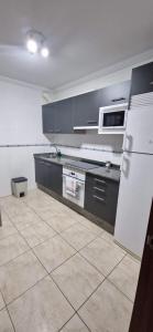 博伊罗Piso al lado de la playa的厨房配有黑色橱柜和白色冰箱。