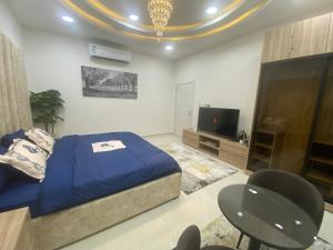 哈萨التوفيق للوحدات السكنية T1的一间卧室配有一张床、一台电视和椅子