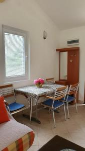 里桑欧吉诺维奇公寓的用餐室配有桌椅和鲜花