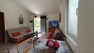 里桑欧吉诺维奇公寓的客厅配有沙发和鲜花桌