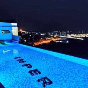 阿罗士打D'yana Imperio Homestay的游泳池,晚上可欣赏到城市景观