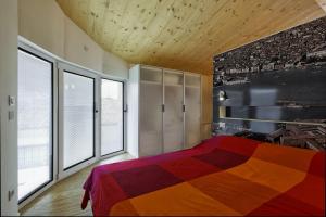 法瓦罗威尼托生态威尼斯公寓的一间卧室设有一张色彩缤纷的床和大窗户