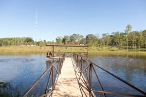 AtyráGranja 17 de Noviembre的一座湖上的桥,湖中有鸭子
